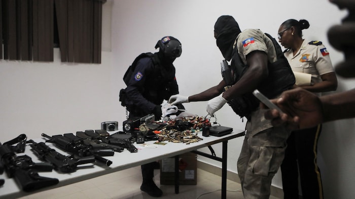 Des policiers montrent des armes sur une table.