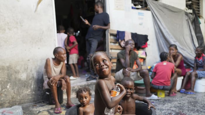 Des enfants se baignent dans un abri de fortune pour les personnes déplacées par la violence des gangs à Port-au-Prince.
