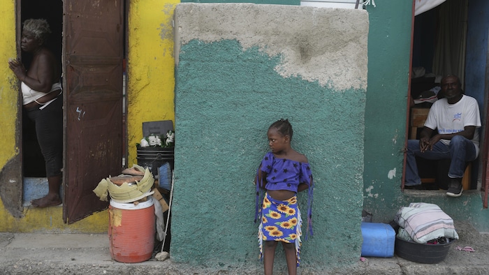 Des gens regardent une rue du quartier Simon-Pele à Port-au-Prince.