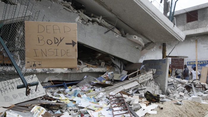 Une pancarte indique la présence de corps sous les décombres d'un immeuble effondré à Port-au-Prince, le 19 janvier 2010.