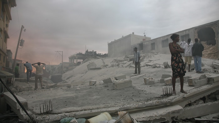 Des gens errent, hagards, dans un paysage de désolation.