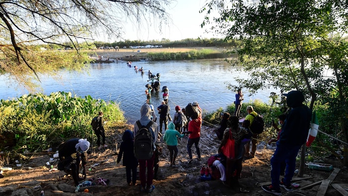 De nombreuses personnes traversent un fleuve pour rejoindre l'autre rive.