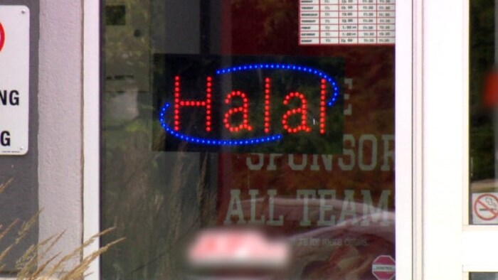 Un signe dans une fenêtre qui dit halal.