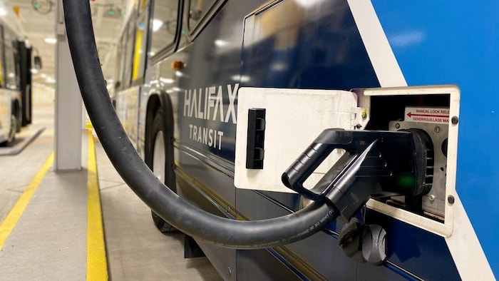 Un autobus électrique d'Halifax Transit stationné dans un hangar est en train de charger.