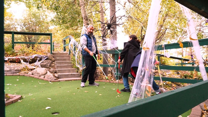 Une famille joue au mini-golf.