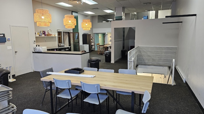 Un espace cuisine comprend une table et des chaises.