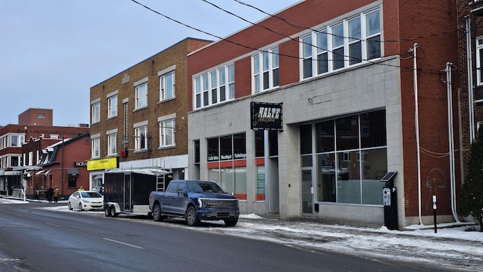 Des édifices sont en bordure d’une rue en hiver.