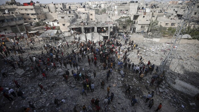 فلسطينيون يتفقدون الدمار الناجم عن قصف إسرائيلي على مخيم خان يونس للاجئين في جنوب قطاع غزة.