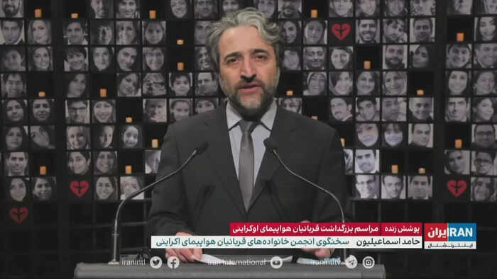 Hamed Esmaeilion junto a un collage de fotos de las víctimas de la tragedia aérea.