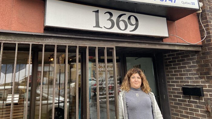 Une femme dehors devant la porte d'un bureau