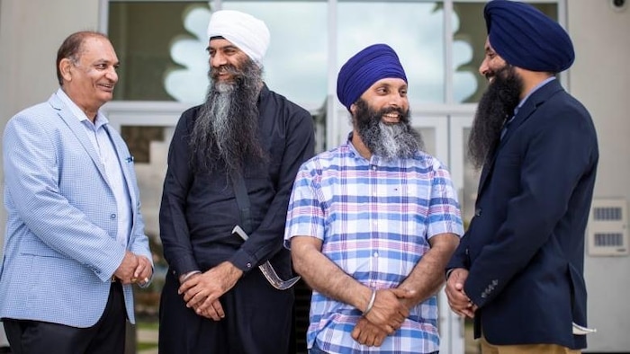 Quatre hommes, dont trois qui appartiennent à la communauté sikhe.