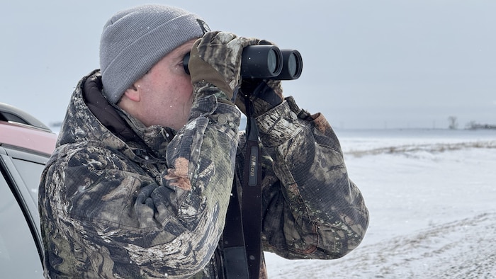 Stéphane Canevet observe avec une paire de jumelles. 