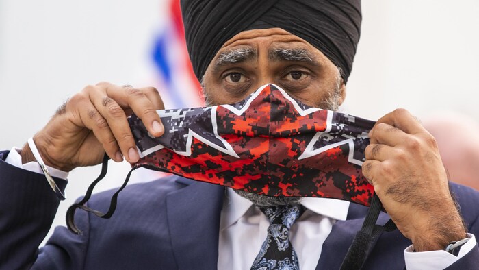 M. Sajjan mettant un masque aux couleurs de l'unifolié.