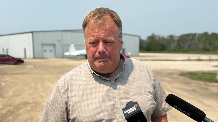 Adam Penner s'adresse aux médias sur les terrains de l'école de pilotage Harv's Air dans les environs de Steinbach. (8 juillet 2025)