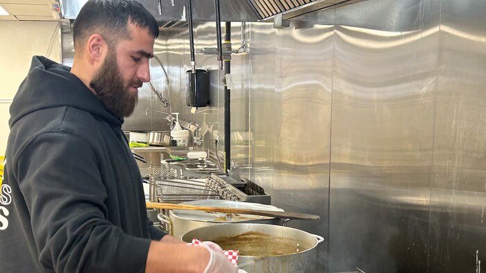Hasib Karimi devant un grill. 
