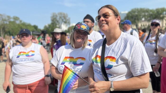 Heather Stefanson entourée de membres du Parti progressiste-conservateur du Manitoba, vêtu d'un chandail blanc avec le logo du parti aux couleurs de l'arc-en-ciel, le 4 juin 2023. 