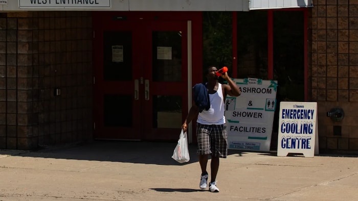 A man leaves a community centre in Toronto during a heat wave earlier this month. Some cities have been opening cooling centres during heat waves for people who do not have access to air conditioning.