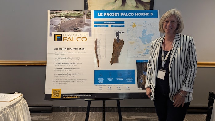 Hélène Cartier est debout près d'un panneau présentant le projet Falco Horne 5.