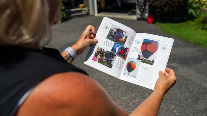 Elle tient un livre ouvert dans lequel sont détaillées les étapes nécessaires pour gonfler un ballon.
