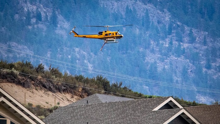 Lumilipad na helicopter sa itaas ng mga bahay.