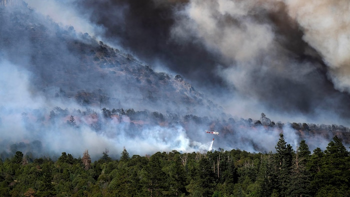 Un hélicoptère largue de l'eau au-dessus du feu de forêt de Gold Mountain, au Colorado.