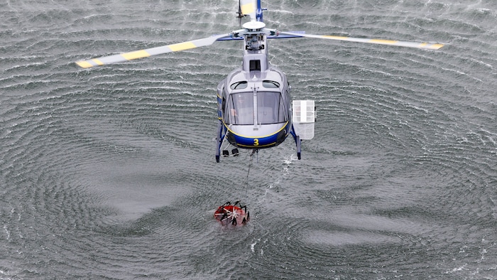 Un hélicoptère ramasse une poche d'eau.
