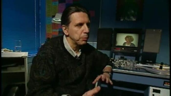 Herménégilde Chiasson devant une télévision.
