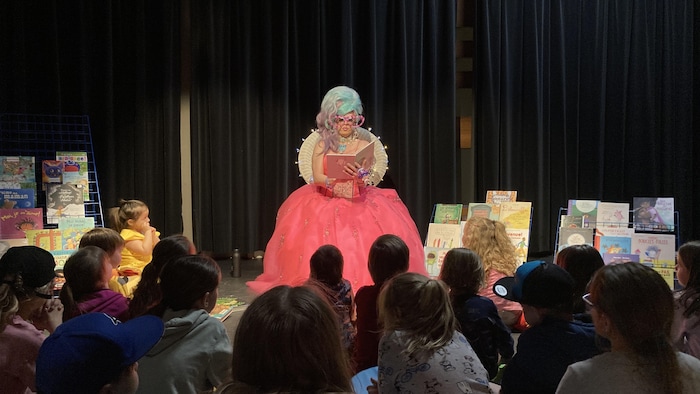 Une drag queen lit des histoires à des enfants.