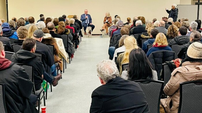 Blaine Higgs parle à quelques dizaines de personnes dans une salle.