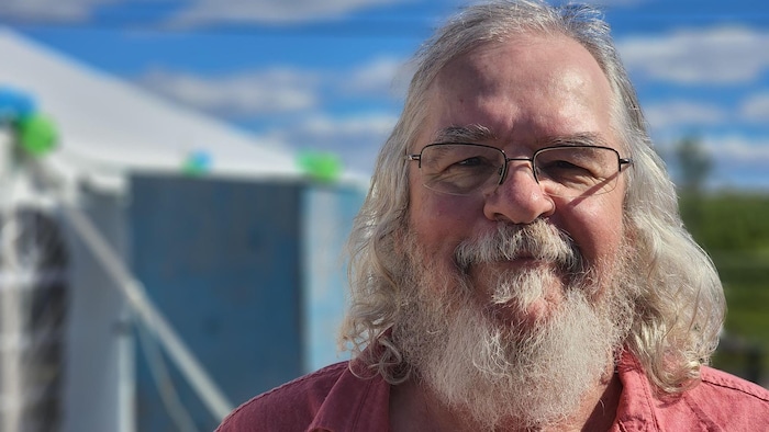 L'historien Jean-Marie Thibeault devant le chapiteau où se déroulaient les activités d'inauguration.