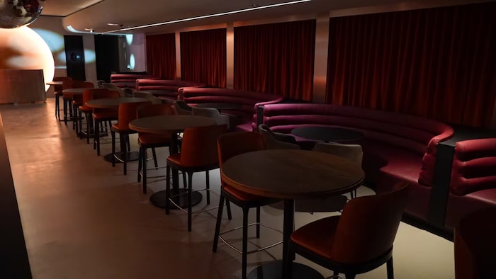 Des tables, chaises et banquettes à l'intérieur de la salle.
