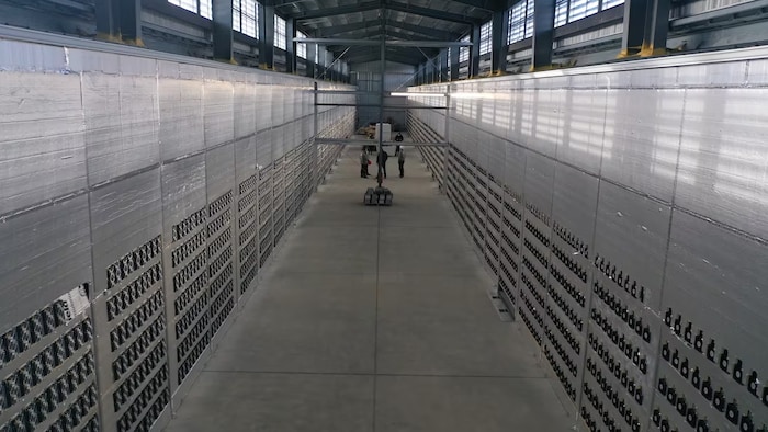 Des centaines d'ordinateurs le long des murs d'un entrepôt.