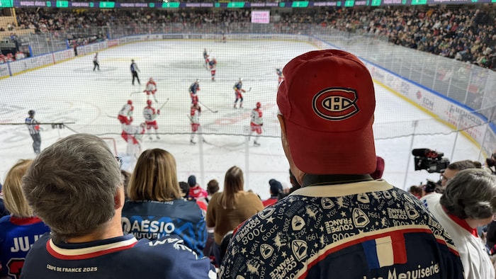 Des partisans de dos dans les gradins d'un amphithéâtre de hockey.