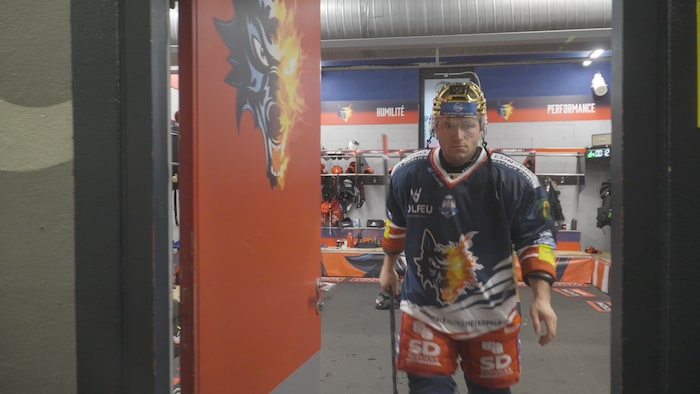 Un joueur de hockey sort de son vestiaire.