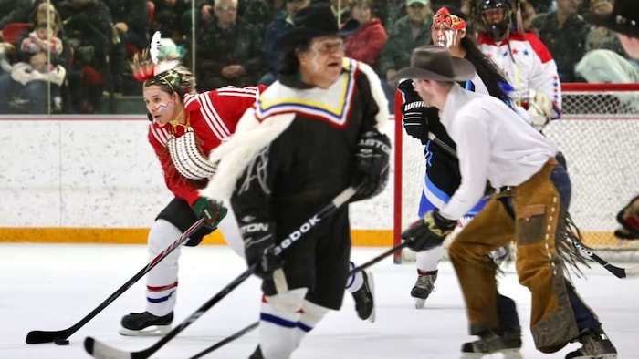 Des joueurs autochtones affrontent des cowboys dans une partie de hockey amicale.