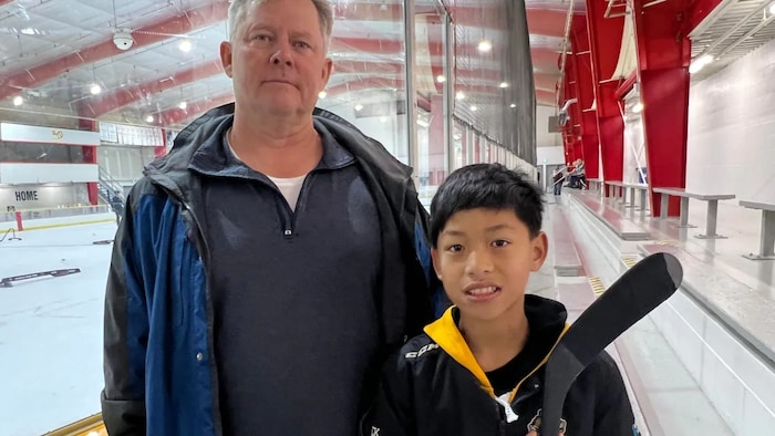 Un jeune joueur de hockey et son père.