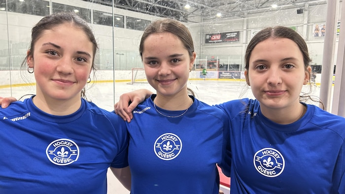 Trois jeunes femmes devant une patinoire.