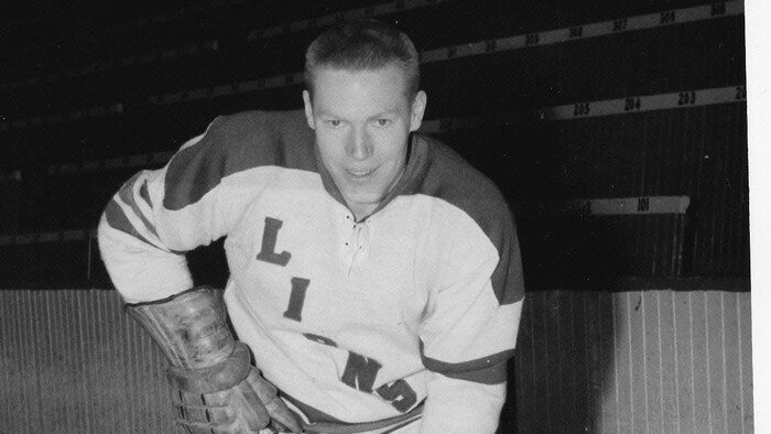 Une photo d'époque d'un joueur de hockey en uniforme sur la glace.
