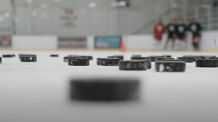 Des rondelles de hockey sur une patinoire intérieure.