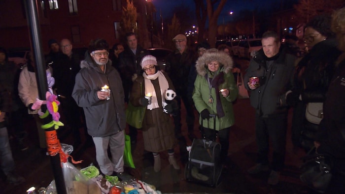 Des personnes rassemblées portant des bougies.