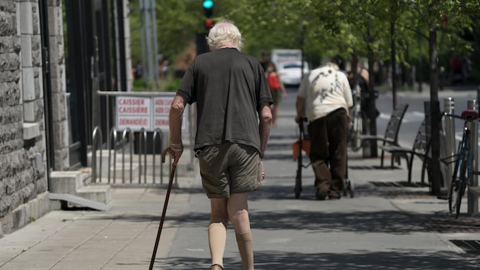 Des personnes âgées se déplacement sur la rue Laurier, par une chaude journée ensoleillée.