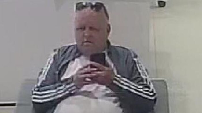 Un homme assis sur une chaise.