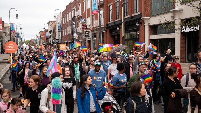 Des centaines de personnes portant les couleurs de la communauté LGBTQ+ marchent dans le centre-ville de Trois-Rivières. 