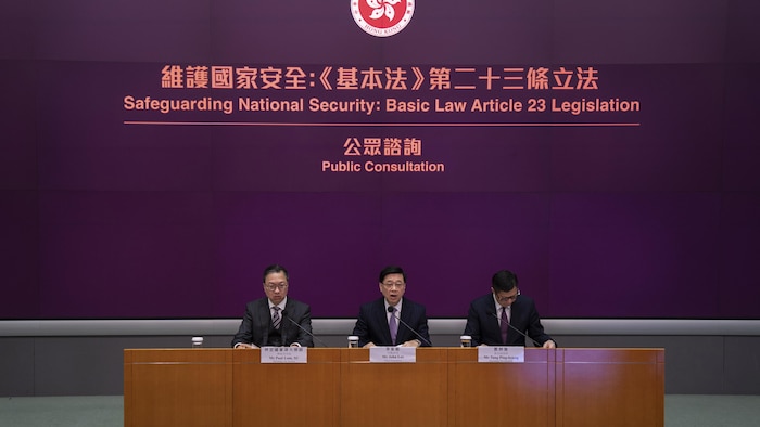 Hong Kong Chief Executive John Lee, center, Secretary for Justice Paul Lam, left, and Secretary for Security Chris Tang in a press conference.