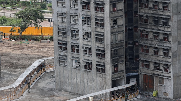 Des résidents transportent des effets personnels récupérés au complexe d'appartements Wang Fuk Court lors de leur première visite sur les lieux, le 20 avril 2026.