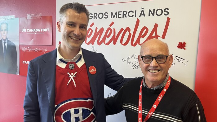 Le candidat libéral dans Honoré-Mercier, Eric St-Pierre, avec lad bénévole le positive fidèle, Joe Sciascia, devant une affiche de remerciements dans lad section électoral.