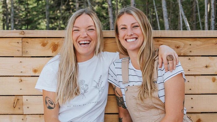 Une photo de deux femmes souriantes dans la nature. 