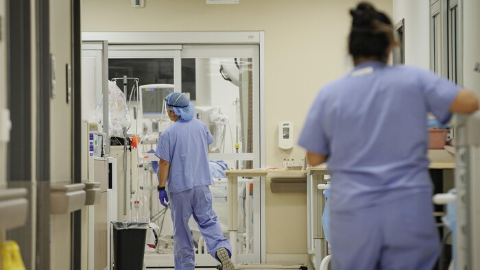 Des infirmiers s'affairent dans un couloir de la salle d'urgence d'un hôpital.