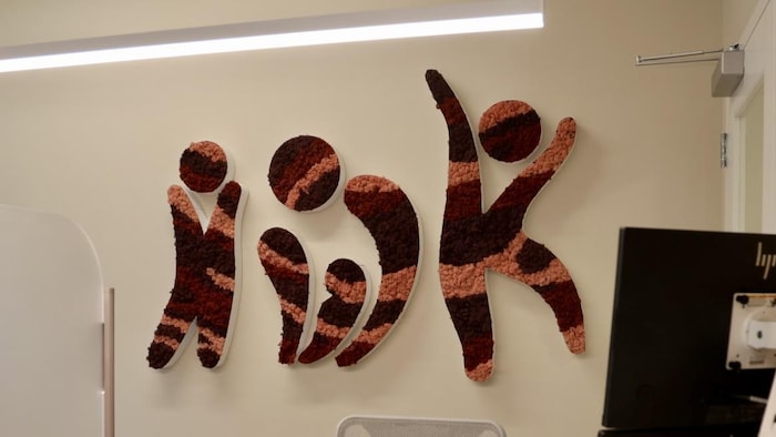 Une décoration sur le mur représente des personnages épelant les lettres I, W et K.