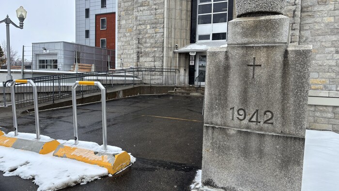 Une pierre angulaire où sont gravées l'année 1942 et une croix est encastrée dans un des murs de pierre près de l'entrée de l'édifice.